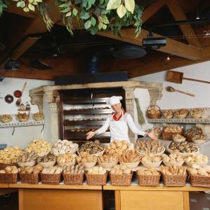 a woman standing in front of a bakery with bread at Landzeit Motor-Hotel St. Valentin in Sankt Valentin +14 photos