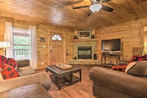 een woonkamer met een open haard en een televisie bij Cabin with Deck and Fireplace Less Than 3 Mi to Dollywood! in Pigeon Forge