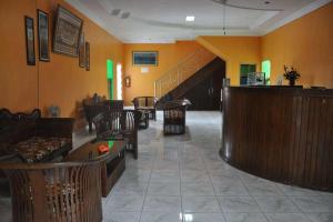 un vestíbulo con sofás, un bar y un vestíbulo en RedDoorz near Lokawisata Baturaden, en Purwokerto