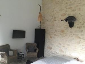 a bedroom with a stone wall with a hat on the wall at LE MAS DES AUGES in Barjac