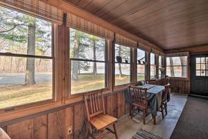a dining room with a table and chairs and windows at Eagles Nest - Baraboo Cabin on Wisconsin River! in Baraboo