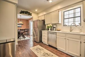 a kitchen with white cabinets and a dining room at Modern Mountain Retreat with Deck and Hot Tub! in Chester Gap