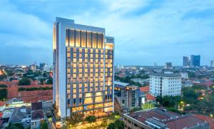 um edifício alto com luzes acesas numa cidade em Grand Swiss-Belhotel Darmo em Surabaya