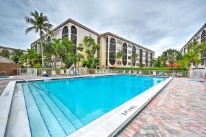 a swimming pool in front of a building at Waterfront Marco Island Condo with Pool and Hot Tub! in Marco Island