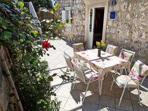 a table and chairs with flowers on a patio at Holiday Home Adriatic Pearl in Dubrovnik