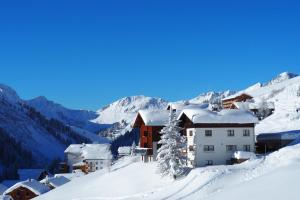 een skigebied in de bergen met met sneeuw overdekte daken bij Haus Furka in Damuls