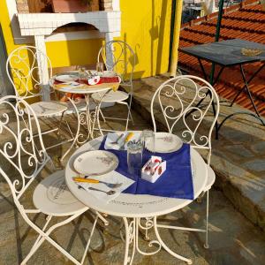 stół z dwoma krzesłami i stół z talerzami w obiekcie La Casa Del Sole w San Remo