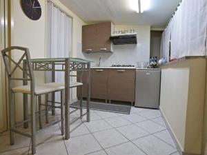 a small kitchen with a table and a refrigerator at A Casa di Claudio in Catania