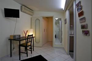 a living room with a table and a television and a hallway at A Casa di Claudio in Catania