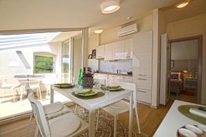 a kitchen and dining room with a white table and chairs at App & Rooms Juraga in Bale