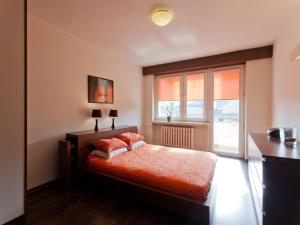 Un dormitorio con una cama con almohadas rojas y una ventana en Irish Apartment, en Cracovia