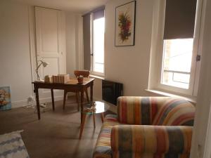 uma sala de estar com um sofá e uma mesa em La petite vadrouille - coeur urbain d'Epernay em Épernay