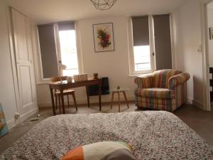a bedroom with a bed and a chair and a desk at La petite vadrouille - coeur urbain d'Epernay in Épernay