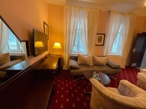 a living room with a couch and chairs in a room at Hotel & Restaurant Bergschlösschen in Buckow