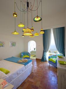 a bedroom with two beds and two chairs and lights at Casa Marta Capri in Capri