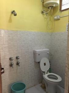 ein Bad mit WC und ein Telefon an der Wand in der Unterkunft Aryan Bungalow 4BHK in Lonavla