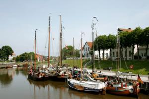 a group of boats are docked in a harbor at Ferienwohnanlage Lübben in Carolinensiel