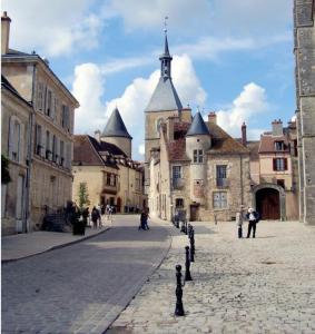 a cobblestone street in an old town with buildings at La Rénovée d’Antan in Avallon