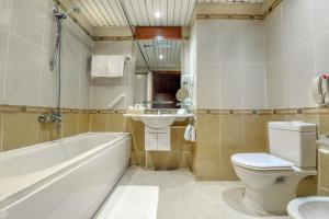 a bathroom with a toilet, sink and tub at Tolip Hotel Alexandria in Alexandria