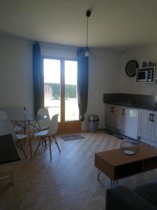 sala de estar con cocina, mesa y sillas en Chambres de Sauviolle 2, en Frontenac