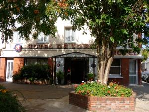 a brick building with a tree in front of it at Hôtel de l'Orme, Akena in Évreux