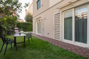 a patio with two chairs and a table in the grass at Villa Capri Apartment and Room in Naples