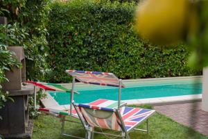 un paio di sedie da giardino sedute accanto alla piscina di Villa Capri Apartment and Room a Napoli