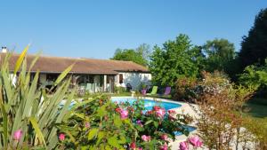 a house with a swimming pool and some flowers at Chambres d'hôte de Sauviolle 2 in Frontenac