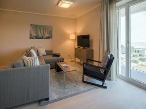 ein Wohnzimmer mit einem Sofa und einem TV in der Unterkunft Dünenresidenz Prora - Ferienwohnung mit Meerblick, 1 Schlafzimmer und Balkon NP-401 in Binz