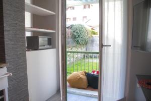 a kitchen with a door open to a balcony at Casa Dante - WelcHome in Stresa