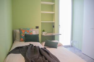 two beds in a room with green walls at Casa Dante - WelcHome in Stresa