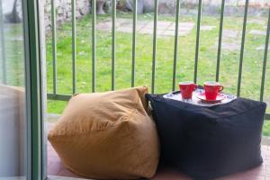 two red cups on a table next to a window at Casa Dante - WelcHome in Stresa