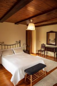 a bedroom with a bed and a mirror and a piano at Lugar del Rio in Couzadoiro