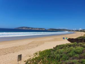 a group of people walking on a beach at Long Story Guest House in Plettenberg Bay