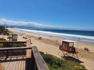 una spiaggia con persone sulla sabbia e sull'oceano di Long Story Guest House a Plettenberg Bay