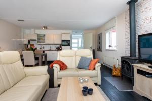 ein Wohnzimmer mit weißen Möbeln und eine Küche in der Unterkunft Antibes 262 - Kustpark Village Scaldia in Hoofdplaat