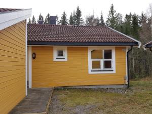 una casa amarilla con una rampa de madera al lado en Seljord Apartment, en Seljord