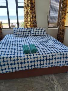 a bed with two green pillows on top of it at Oceans Breeze - Unit 2 Second floor in Durban