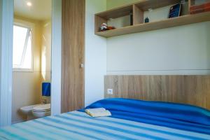 a bedroom with a bed and a desk at Camping Village Mareblu in Marina di Cecina