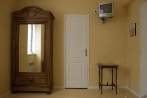 Habitación con puerta, espejo y mesa. en Hôtel Ladagnous, en Peyrouse