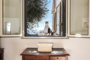 una mesa frente a una ventana con una botella en Villa Farniente San Gregorio, en Morciano di Leuca