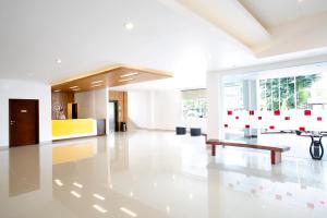 a white lobby with a table and a bench at Amaris Hotel Muara Bungo - Jambi in Bebeko