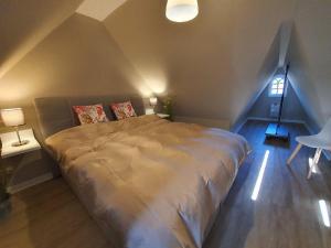 a bedroom with a large bed in a attic at Hues-Sylt in Morsum