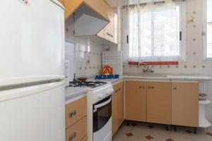 eine Küche mit einem weißen Herd oberer Ofen neben einer Spüle in der Unterkunft El Raco, A-7-13 in Cullera