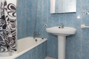 ein blau gefliestes Badezimmer mit einem Waschbecken und einer Badewanne in der Unterkunft El Raco, A-7-13 in Cullera + 11 Fotos