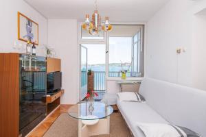 a living room with a couch and a glass table at APARTMA MILENA in Koper