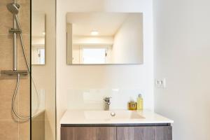 een badkamer met een wastafel en een spiegel bij Diamant Studio in Brussel