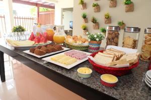a buffet with cheese and other foods on a counter at Anauê Pousada e Hostel in Aracaju