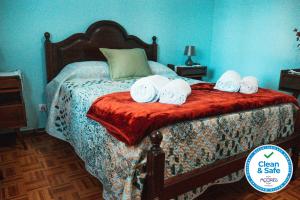 a bedroom with a bed with towels on it at Cordeiro's House in Arrifes