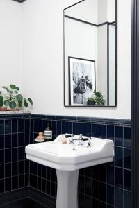 a bathroom with a white sink and a mirror at Contemporary Studio - minutes from Angel Tube St. in London